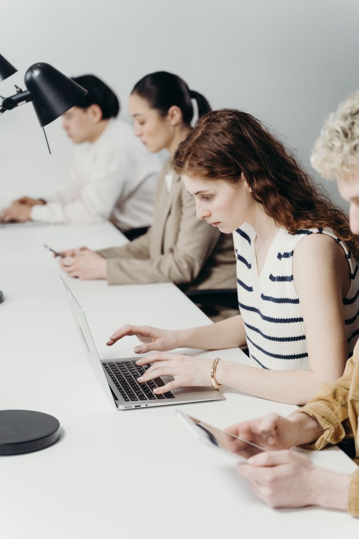 Crafting Captivating Headlines: Your awesome post title goes here Diverse group of professionals working intently on laptops in a modern office.